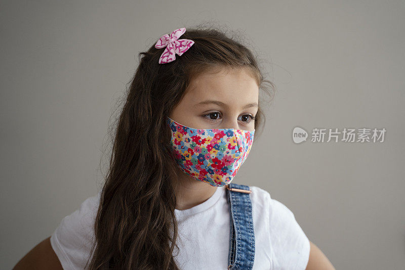 Portrait of 8 year old cute girl wearing homemade protective mask during quarantine